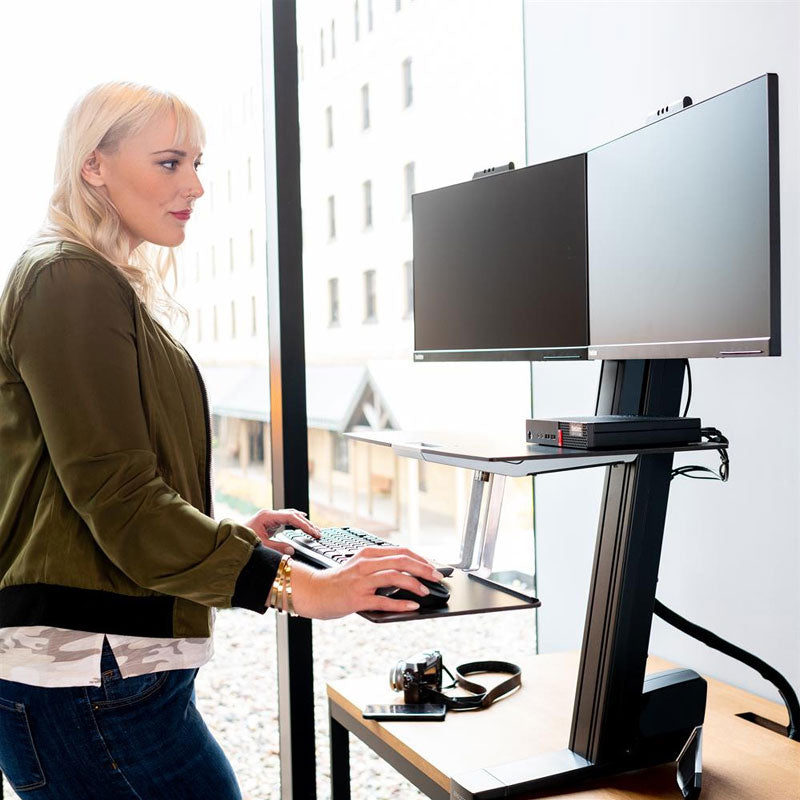 Ergotron Sit-Stand Desk Mount 33-349-200, standing person using a dual-monitor sit-stand workstation