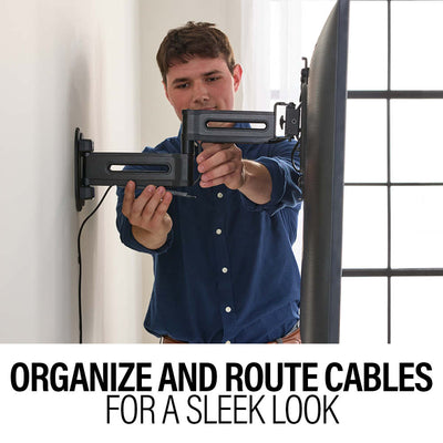Sanus Small Adv Full-Motion 4D + Shift TV Mount VSF817-B2, person organizing cables through a wall mount