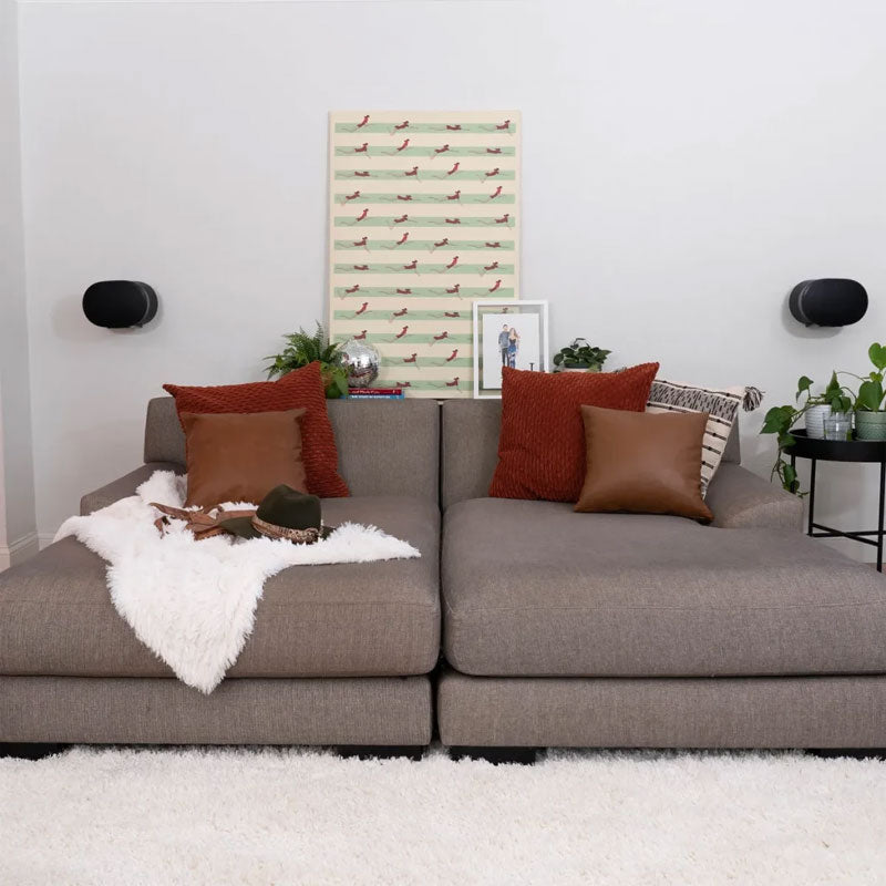 Sanus Adjustable Speaker Wall Mounts WSWME32-B2, pair of wall-mounted speakers installed above a sofa
