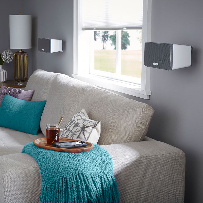 Sanus Wireless Speaker Wall Mount WSWM22-W1, black and white speakers wall-mounted over sofa