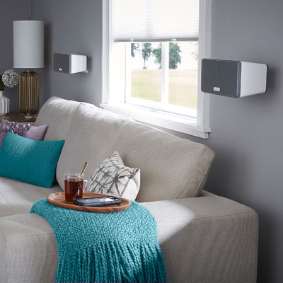 Sanus Wireless Speaker Wall Mount WSWM22-W1, black and white speakers wall-mounted over sofa